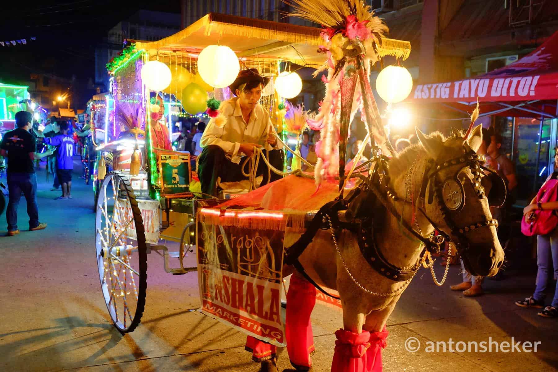 Horse-drawn carriage adorned with colorful lights and flowers dazzles in Iligan Citys vibrant nighttime parade.